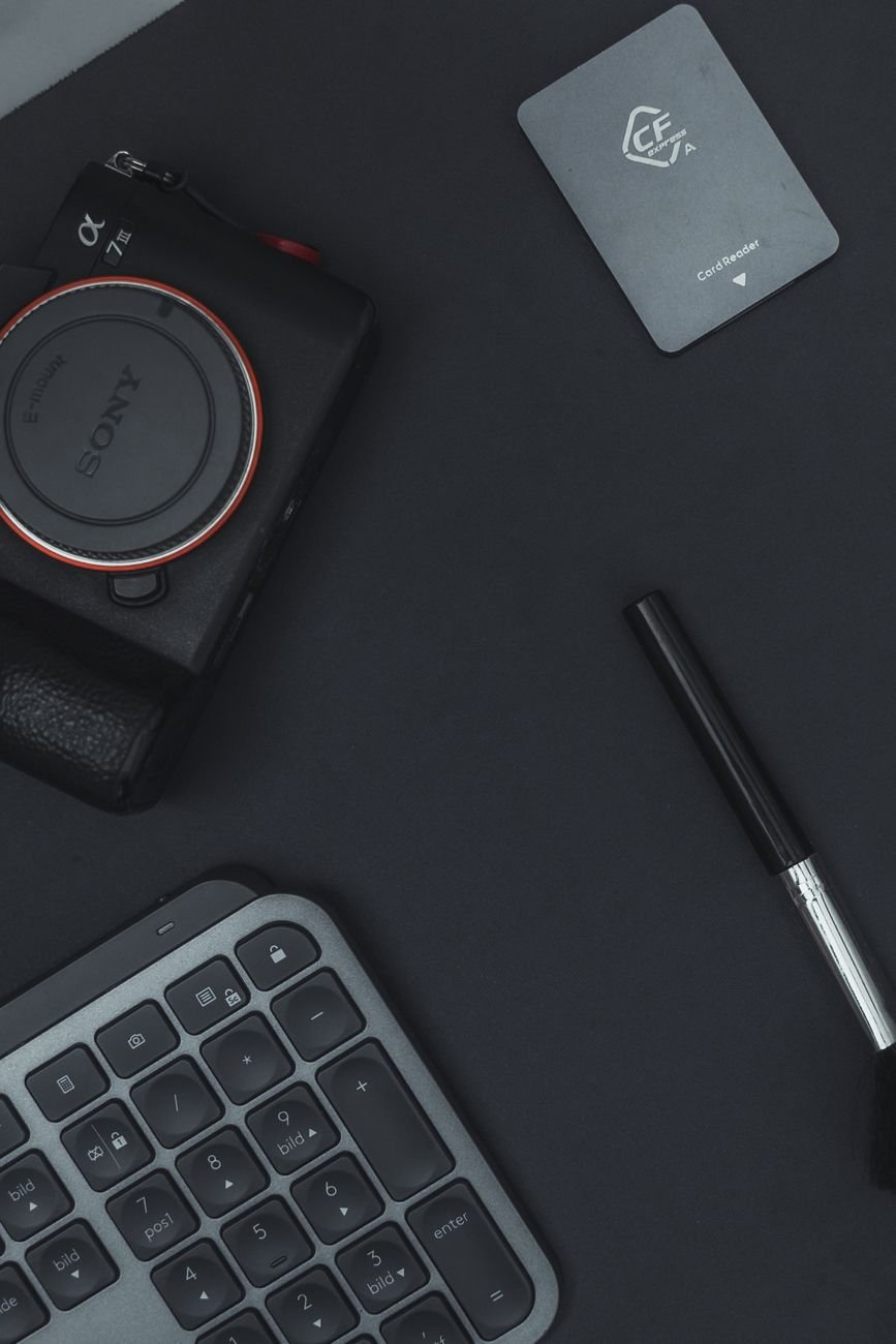 Dark studio flat lay of camera and keyboard — content creation workspace